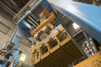 Brickyard. Bottom view of production machine with bricks