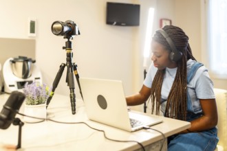 Young girl recording a vlog at home, using a camera, headphones, and microphone, immersed in her