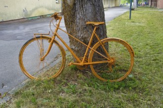 Yellow bicycle leaning on tree trunk, decoration, painted, Albgut, old camp, former military area,
