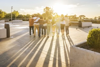 Rays of the sunset illuminating a group of friends having fun strolling together at city