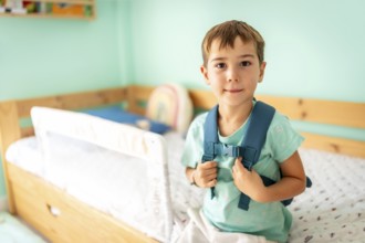 Portrait of a schoolboy with school bag ready for first day at school smiling at camera in the