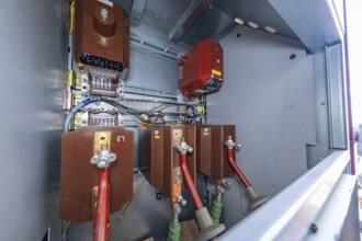 View into an open switch box with visible electrical components and cabling, switch cabinet