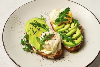 Sandwich with cream cheese, sliced avocado and boiled egg, arugula, on grainy bread, homemade,