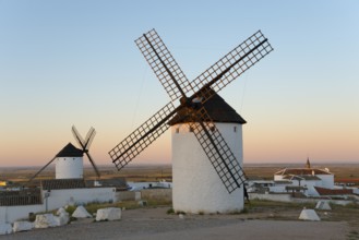 White windmills stand in a rural landscape under a gentle morning sky, Campo de Criptana, Ciudad