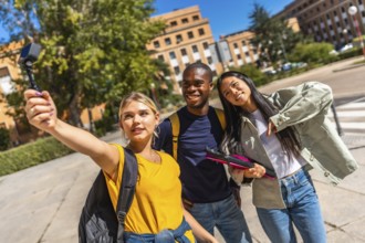 Multi-ethnic university students streaming online with small digital camera standing on the campus
