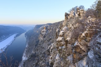 Kanapee viewpoint at the Bastei into the snow-covered Elbe valley with sandstone cliffs such as the