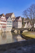 Old bridge over a river with half-timbered houses and clear sky in the background, Schwäbisch Hall,