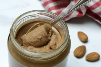 Almond cream in jar with spoon, almond spread