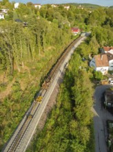 Railway tracks run through a village surrounded by trees, track construction, rail delivery for