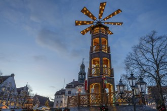 Large Christmas pyramid at the Christmas market at dusk, behind the historic town hall, Lüneburg,