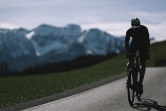 Road bike rider in spring near Halblech in the Allgäu in front of a picturesque backdrop of the