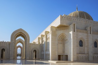 Arched gates and large hall with dome of the Sultan Qaboos Mosque, Muscat, Arabian Peninsula,