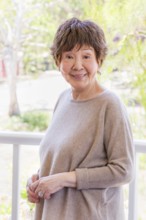 Happy senior chinese woman poses for her portrait outdoors
