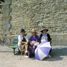 Women on a bench in front of the city wall of St.Malo, Brittany, France