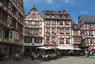 Lively square in the old town centre with half-timbered houses and cafés in sunny weather, market