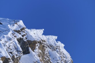 Snow-covered mountain peak with snow cornices under a clear blue sky, Gemmi Pass, Plattenhörner,