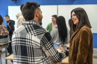 Multi ethnic university students chatting with their teacher after class, discussing lesson topics