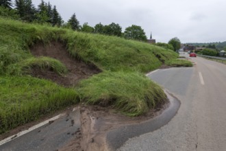 Symbolic image of climate change, slippery slope on a country road after heavy rainfall, near