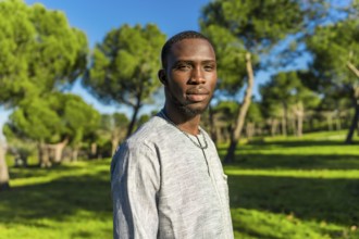 Portrait of a young african man from senegal wearing traditional clothing in a park, representing