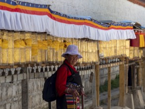 Pilgrims at golden prayer wheels, Xigaze, Tibet, China