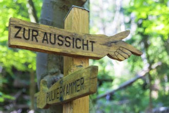Wooden hiking sign points the way to the view or to the powder magazine, at the Zschirnstein,