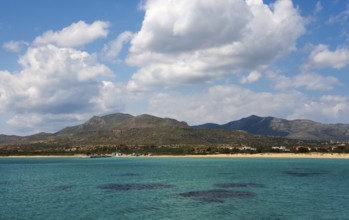 A wide view over the sea with mountains and clouds in the background, view to Pounta beach near