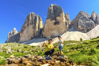Mother and child waving near tre cime di lavaredo, dolomites, italy, enjoying summer vacation