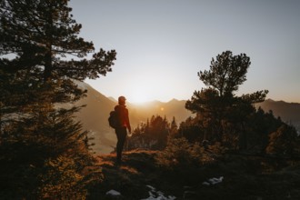 Hiker in the Allgäu at sunset in spring on the Zirmgrat near Pronten in the Allgäu