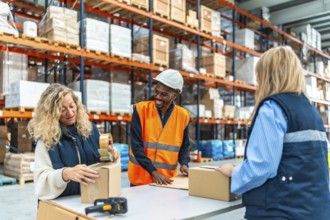 Multiracial male and females warehouse workers talking while preparing packages to deliver