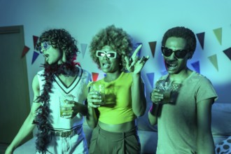 Multi-ethnic young students dancing and drinking alcohol during night party at home