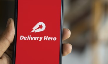 Delivery Hero logo is displayed on smartphone