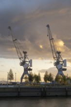 Dramatic clouds over the Strandkai, historic crane, sunset, Überseequartier, Hafencity, Hamburg,