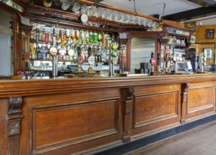 Traditional wooden bar counter with beer pumps inside Nova Scotia Hotel public house bar, Bristol,