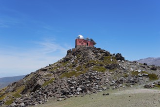 Red observatory building on a rocky hill under a blue sky, Obversatorium, Mohon del Trigo
