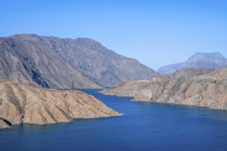 Blue Toktogul reservoir between dry mountain landscape, Jalalabad region, Kyrgyzstan