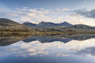 Reflection of the autumn landscape in Rondane National Park, mountains Høgronden, Midtronden and