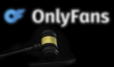 Court gavel in front of the OnlyFans logo. OnlyFans is an internet content subscription service