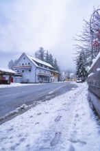 Snow-covered road with building in the background, Enzklösterle, Calw district, Black Forest,