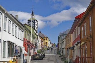 City street with colourful buildings, a striking church and light clouds in the blue sky, Unesco