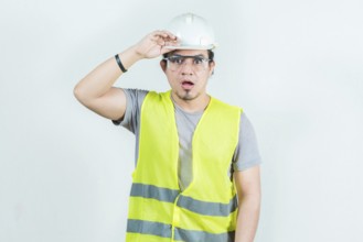 Surprised engineer looking into the distance isolated. Amazed latin engineer looking into the