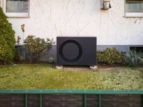 A black heat pump in a front garden in Langenfeld, Germany