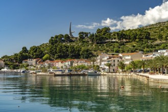 The Riva waterfront promenade and the seagull wing monument in Podgora, Croatia