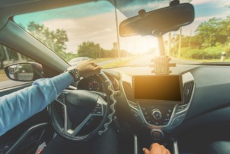 Driver hands on the steering wheel while driving on the asphalt. View of the driver hands driving