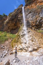 Female hiker enjoying majestic rinka waterfall in picturesque logarska dolina valley, savinja alps,