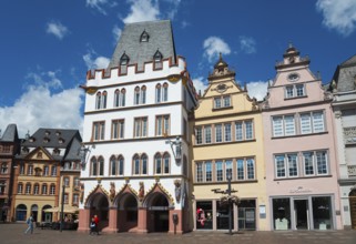 Colourful historic buildings in Gothic style with towers and windows on a lively town square under