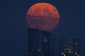 The full moon rises over the European Central Bank (ECB) in Frankfurt am Main, Frankfurt, Hesse,