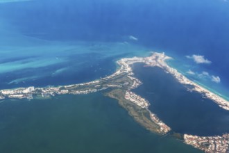 Aerial view through plane window of Caribbean coastline buildings in the hotel zone, Cancun,