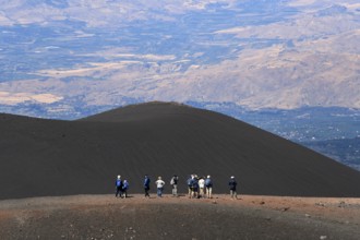 Hikers in the crater landscape of the volcano Etna, summit region, province of Catania, Sicily,