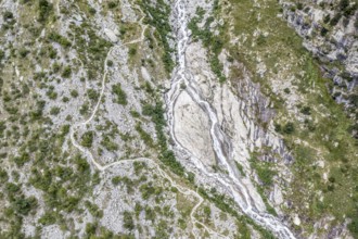 Aerial view, glacial stream flows around a large rock, hiking path from La Fouly to Cabane de