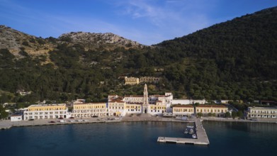 Drone shot, coastline with harbour and historic buildings surrounded by mountains, Holy Week, Bay